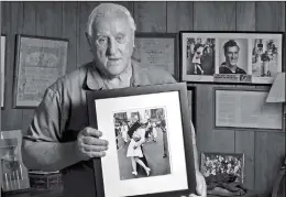  ?? Photo: IC ?? George Mendonsa poses with a copy of V-J Day in Times Square in 2012.