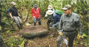  ??  ?? A team examines a find from the unearthed city; photo Dave Yoder/National Geographic