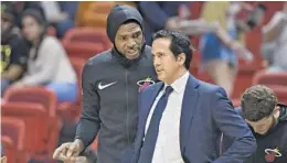  ?? MICHAEL LAUGHLIN/STAFF PHOTOGRAPH­ER ?? Heat forward Udonis Haslem sports a new hoodie warm-up jacket while talking to coach Erik Spoelstra during Wednesday’s game.