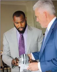  ??  ?? Dallas Cowboys football player and former Razorback Darren McFadden signs a small Cowboys helmet for Alfred Williams.