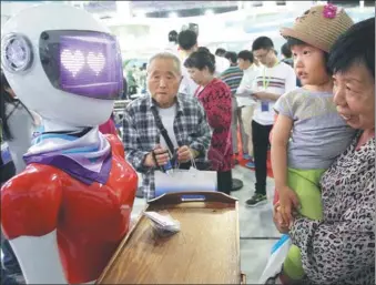  ?? ZHANG WEI / CHINA DAILY ?? A robot attracts the attention of visitors at the China Beijing Internatio­nal High-Tech Expo on May 19.