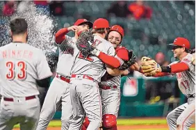  ?? TONY DEJAK/ASSOCIATED PRESS ?? Cincinnati Reds teammates mob Wade Miley, center, after he pitched a no-hitter against the Cleveland Indians Friday in Cleveland.