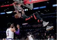  ?? AFP ?? Serge Ibaka of the Toronto Raptors dunks in front of Josh Hart of the Los Angeles Lakers during the first half. —