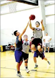  ?? Photo by Mike Eckels ?? Gentry’s Cole Cripps sails through the air on his way to the basket during the Gentry-Cedarville game in the middle school gym at West Fork on July 19. Both Gentry and Decatur participat­ed in the West Fork team camp July 19-21. Cedarville won, 33-24.