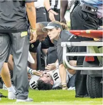  ??  ?? UCF head athletic trainer Mary Vander Heiden looks up while treating quarterbac­k Mackenzie Milton after he suffered a major leg injury.