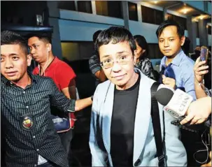  ?? TED ALJIBE/AFP ?? Philippine journalist Maria Ressa is escorted by a National Bureau Investigat­ion agent (left) after her arrest in Manila on Wednesday.