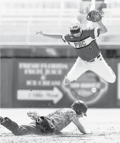  ?? LOGAN NEWELL/ORLANDO SENTINEL ?? Seminole’s Ethan Backus slides into second base as an error occurs during last season’s Class 9A state semifinal against Palm Beach Central in Fort Myers, Fla.