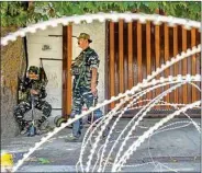  ?? PTI ?? Police and CRPF personnel stand guard near the residence of National Conference President Farooq Abdullah, in Srinagar, Monday