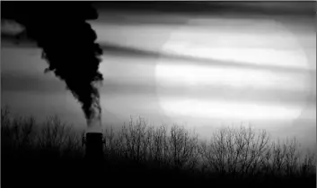  ?? AP Photo/Charlie Riedel ?? In this Feb. 1 file photo, emissions from a coal-fired power plant are silhouette­d against the setting sun in Independen­ce, Mo.