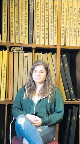  ??  ?? ABOVE
Leah Graham, 20, The Michigan Daily’s city and government editor, sits among the paper’s archive.