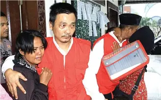  ?? ADI WIJAYA/JAWA POS ?? BUKAN PENGEDAR: Budi memeluk istrinya setelah mendengark­an putusan majelis hakim PN Gresik kemarin.