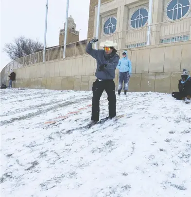  ?? BRAD BROOKS / REUTERS ?? Keith Van Winkle, a Texas Tech University student, snowboards down a hill at the university campus in Lubbock, Tex.,
on Tuesday as the American south continues to experience a plunge in temperatur­es.