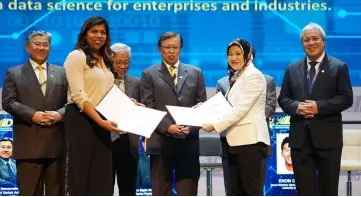  ??  ?? Sharala (front, left) exchanges the MoU documents with Asleena at IDECS 2018, witnessed by Abang Johari (centre). Also seen (back, from left) are Morshidi, Masing and Awang Tengah.