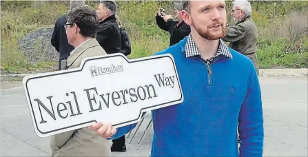  ?? METROLAND KEVIN WERNER ?? Neil Everson's son, Bill, with a commemorat­ive road sign after Hamilton officials renamed Cormorant Road in the Ancaster Business Park.