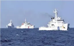  ?? ?? The Yomiuri Shimbun Japan Coast Guard boats confront a China Coast Guard boat (center) off the Senkaku Islands.