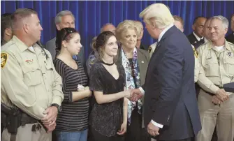  ?? AP PHOTOS ?? CONSOLING TONE: President Trump greets first responders and citizens who aided at Sunday’s mass shooting after meeting Dr. John Fildes, left, in Las Vegas.