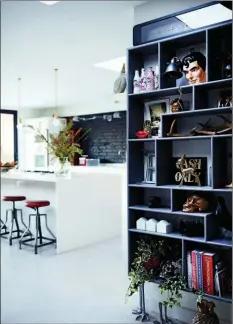  ??  ?? Kitchen and book shelves: A welcome display of personal and fun family objects balance a clinical white and black kitchen.