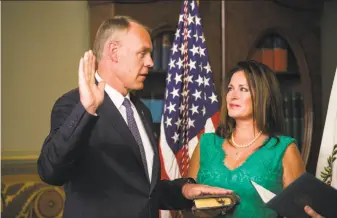  ?? Al Drago / New York Times ?? Ryan Zinke — with his wife, Lola, watching — is sworn in as secretary of the interior by Vice President Mike Pence at the Eisenhower Executive Office Building in Washington.