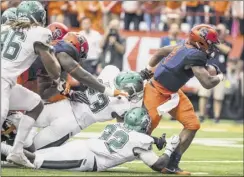  ?? Brett Carlsen / Getty Images ?? Dontae Strickland of Syracuse drags Wagner players with him on this first-quarter run. The Orange scored 45 points in the first half.