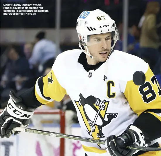  ?? PHOTO AFP ?? Sidney Crosby jonglant avec la rondelle avant la cinquième rencontre de la série contre les Rangers, mercredi dernier.