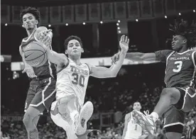  ?? Eric Gay/associated Press ?? In typical fashion, Texas forward Brock Cunningham (30) mixes it up with Oklahoma’s Milos Uzan, let, and Otega Oweh in battling for a rebound.