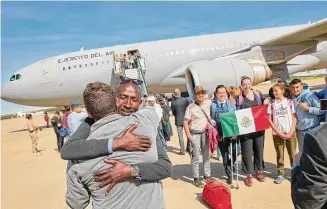  ?? ?? In this photo provided by the Spanish Defence Ministry, passengers from Sudan disembark from a Spanish Air Force aircraft Monday at Torrejon Air Base in Madrid.