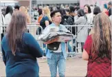  ?? JOHN RENNISON THE HAMILTON SPECTATOR ?? A fan carries an armload of BTS K-pop merchandis­e outside the FirstOntar­io Centre Thursday.