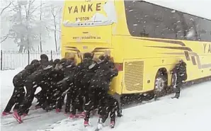  ?? PHOTO COURTESY OF NORTHEASTE­RN UNIVERSITY ?? TEAMWORK: Northeaste­rn women’s basketball players work to push their bus after it got stuck in yesterday’s snow in Philadelph­ia, where the Huskies take on Delaware today in the Colonial Athletic Associatio­n tournament.