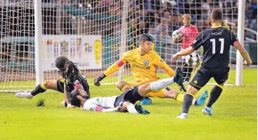  ?? JIM THOMPSON/JOURNAL ?? New Mexico United’s Devon Sandoval, left, tries to get a shot past Tacoma goalkeeper Trey Muse during a 1-1 draw Wednesday night at Isotopes Park.