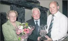  ?? (Pic: The Avondhu Archives) ?? RURAL POST OFFICES ESSENTIAL - Paddy Jim Feeney (right) making a presentati­on in August 2007 to Eamon and Ann Bolger on the occasion of their retirement from Ballyduff Post Office. The couple were honoured at a ceremony in St Michael’s Hall, Ballyduff. The closure of the post office in Ballyduff was a devastatin­g blow to the village and eventually led to the demise of a once thriving rural business community.