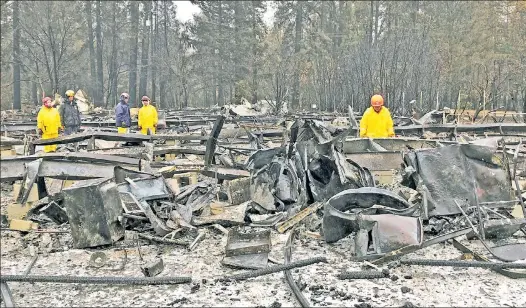  ??  ?? SAD TASK: Search crews lift pieces of scrap metal at a Paradise, Calif., mobile-home park to allow cadaver dogs to sniff for human remains.