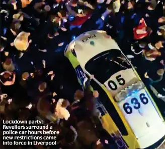  ??  ?? Lockdown party: Revellers surround a police car hours before new restrictio­ns came into force in Liverpool