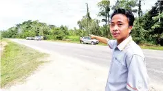  ??  ?? Zainudin Mohd Amin pointing to the road where the accident happened. - Bernama photo