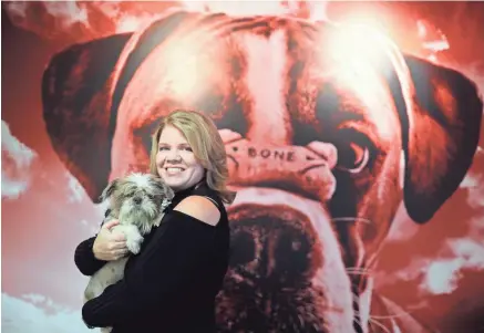  ?? COMMERICAL APPEAL ?? RedRover CEO Lori Turner-Wilson holds 2-year-old Shih-Tzu Gizzy, at her downtown Memphis sales and marketing strategy firm, which has a new campaign guaranteei­ng marketing success with a results or money back initiative and the tagline "I Shih-Tzu Not". Gizzy is currently up for adoption at the Sunny Meadows no-kill animal rescue shelter.