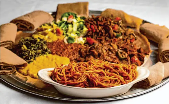  ?? Salgu Wissmath/The Chronicle ?? Spaghetti served with injera and Ethiopian meat and vegetarian dishes at Addis Ethiopian Restaurant in Oakland, Calif.