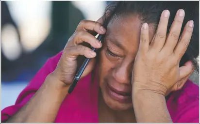  ?? (AP/Julio Cortez) ?? A migrant woman cries as she talks on a cellphone at a park after she and a large group of deportees from the U.S. were pushed by Mexican authoritie­s off an area they had been staying after their expulsion in Reynosa, Mexico.