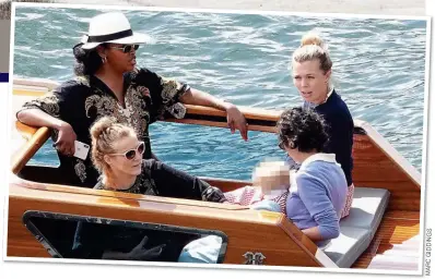  ?? S G N I D I G C R A M ?? GIRLS’ HOLIDAY: Carrie Symonds and baby Wilfred enjoy a boat trip on Lake Como with friends including Nimco Ali, above left