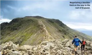  ??  ?? Negotiatin­g a boulder field on the way to the roof of England.