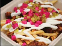  ??  ?? Sharwarma fries at Shawarmaji are topped with turnips, spice-marinated chicken, cucumber pickles and toum.
