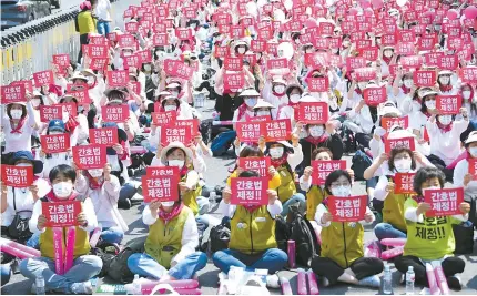  ?? Korea Times photo by Choi Joo-yeon ?? Members of the Korea Nurses Associatio­n and the Korean Health and Medical Workers’ Union stage a rally in Jongno District, Seoul, May 12, calling for legislatio­n of the Nursing Act.