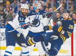  ?? Associated Press photo ?? Buffalo Sabres forward Zemgus Girgensons (28) is checked by Winnipeg Jets defenceman Dustin Byfuglien (33) during the third period of an NHL hockey game, Sunday in Buffalo N.Y.