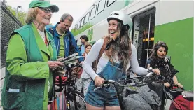  ?? PAUL FORSYTH METROLAND ?? Niagara Falls welcome team captain Barbara Burrows greets cyclists disembarki­ng the GO train at the Niagara Falls train station on Saturday.