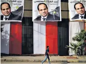  ??  ?? A youth walks past images of Abdel Fattah al-sisi, the Egyptian president, who is aiming to punish online opposition