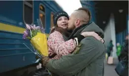  ?? ROMAN HRYTSYNA/AP ?? Ukrainian soldier Vasyl Khomko kisses his daughter Yana on Saturday at a train station in Kyiv. Yana and her mother have been living in Slovakia while the war rages on.