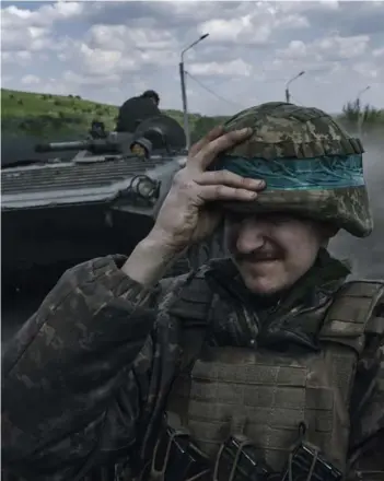  ?? ?? ► Un soldado ucraniano sostiene su casco mientras viaja en un vehículo blindado.