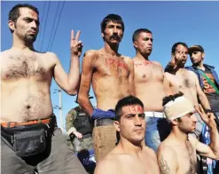  ??  ?? IDOMENI: Migrants and refugees from Iran with their mouths sewn shut sit on railway tracks as they wait to cross the border of Greece and Macedonia (also referred as Former Yogaslavia Rebublic of Makedonia) near Idomeni yesterday. — AFP