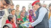  ??  ?? ▪ Akhilesh presents a gift to Khajanchi’s family.