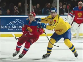  ?? MARISSA BAECKER/Shootthebr­eeze.ca ?? Team Sweden forward Johan Sodergran (13) checks Nikita Shashkov of Team Russia during the second period of Tuesday’s pre-tournament game at Prospera Place.