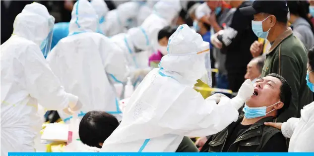  ??  ?? QINGDAO, China: A health worker takes a swab from a resident to be tested for COVID-19 as part of a mass testing program following a new outbreak of coronaviru­s yesterday. — AFP