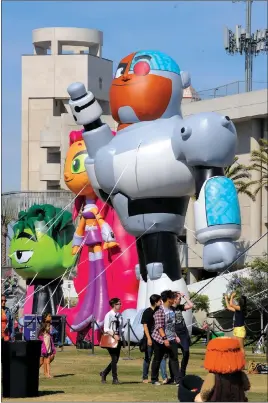  ?? DENIS POROY/ THE ASSOCIATED PRESS ?? Fans walk past inflated “Teen Titans Go” figures outside last year’s Comic-Con festival.